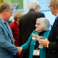 An alumna shakes hands with president T-Haas at the Reunion Dinner.